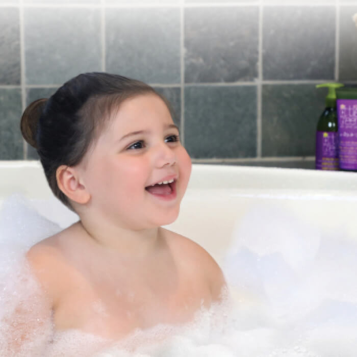 A cute girl taking bubble bath in bath tub